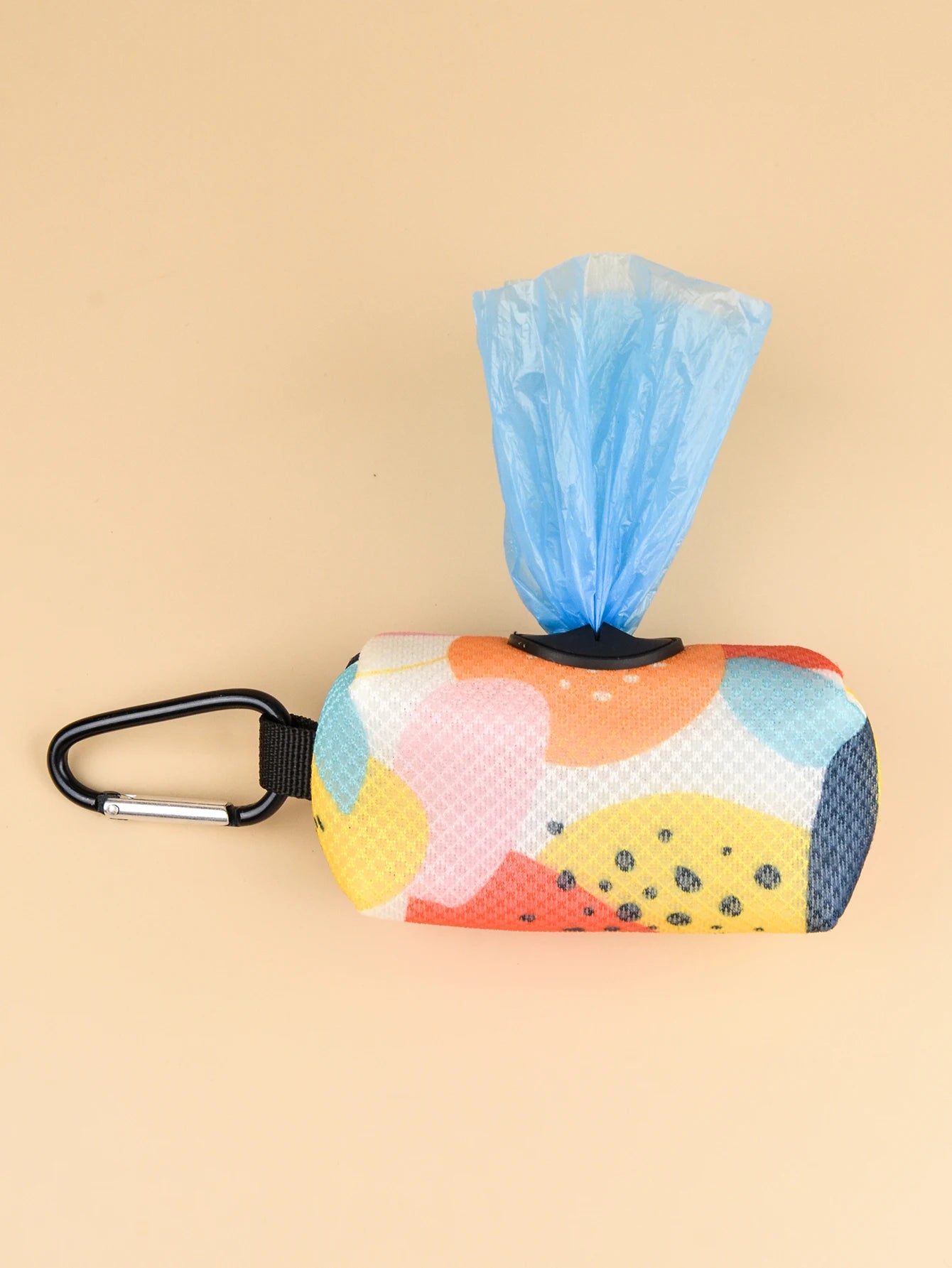 Abstract print dog poop bag holder dispenser with carabiner clip and blue waste bag on beige background