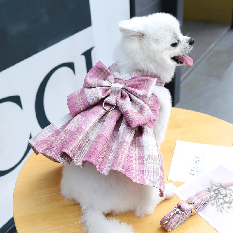 White puppy in plaid pet dress with leash, pink fashion pet outfit with bow for small dogs and cats