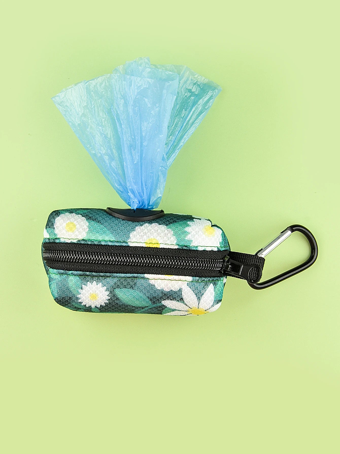 Abstract floral dog poop bag holder dispenser with carabiner and blue waste bags on green background