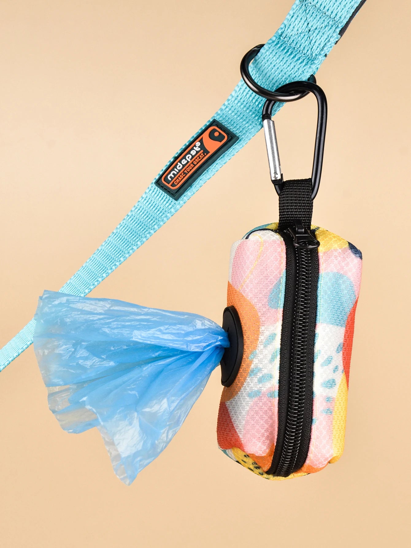 dog poop bag holder dispenser with colorful abstract print, attached to leash, holds waste bags for walking dogs