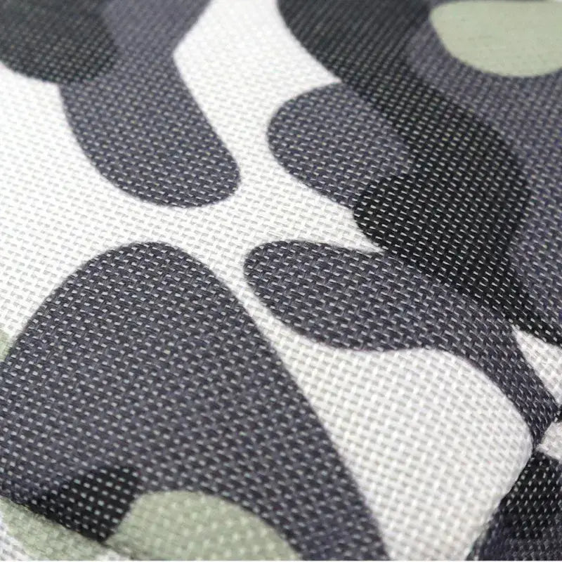 Patterned fabric close-up showcasing textured nylon surface in camouflage design for pet training pouches.