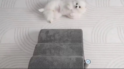 Curved dog ramp for high beds featuring soft grey carpeted steps and a playful dog lying nearby.