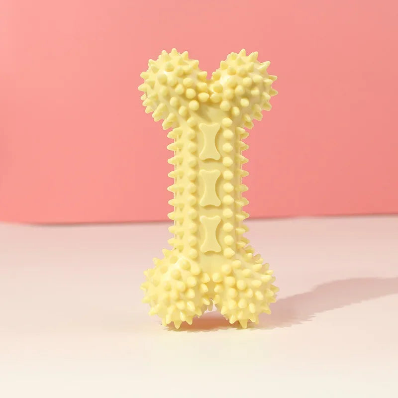 Yellow spiked dog chew toy shaped like a bone on a pastel pink background