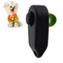 Black dog training clicker with a green strap and a small dog in an orange sweater