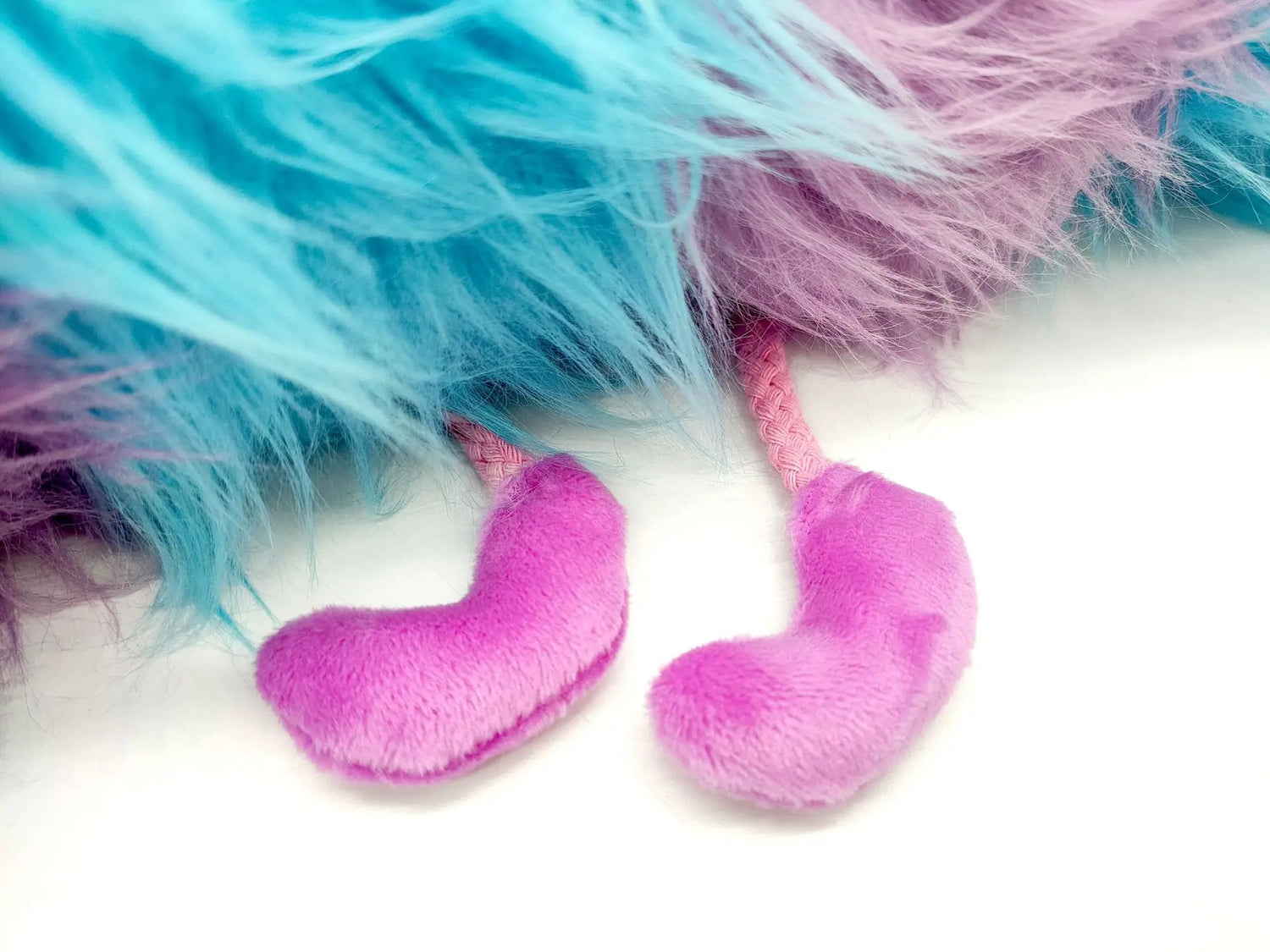 Close-up of the cute legs of a blue purple caterpillar plush toy for kids with fluffy texture.