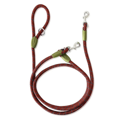 Durable red and black rope dog leash with double clips and loop handle on white background