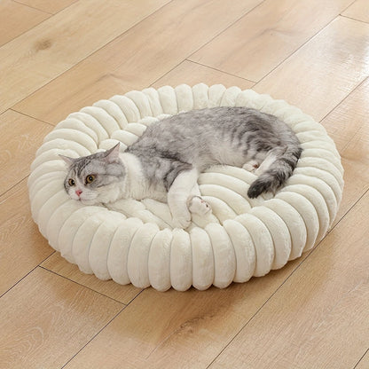 plush donut cat bed with a gray cat resting on a soft round plush pet nest on a wooden floor