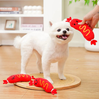 White puppy playing with squeaky plush dog chew toy hot dog on floor indoors