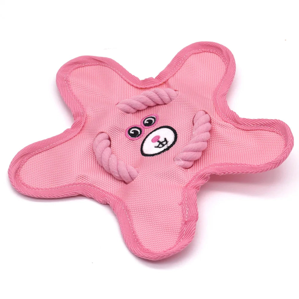 Pink star-shaped dog toy with embroidered animal face and rope details