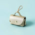 Gold dog waste bag holder with metal clip on a light blue background