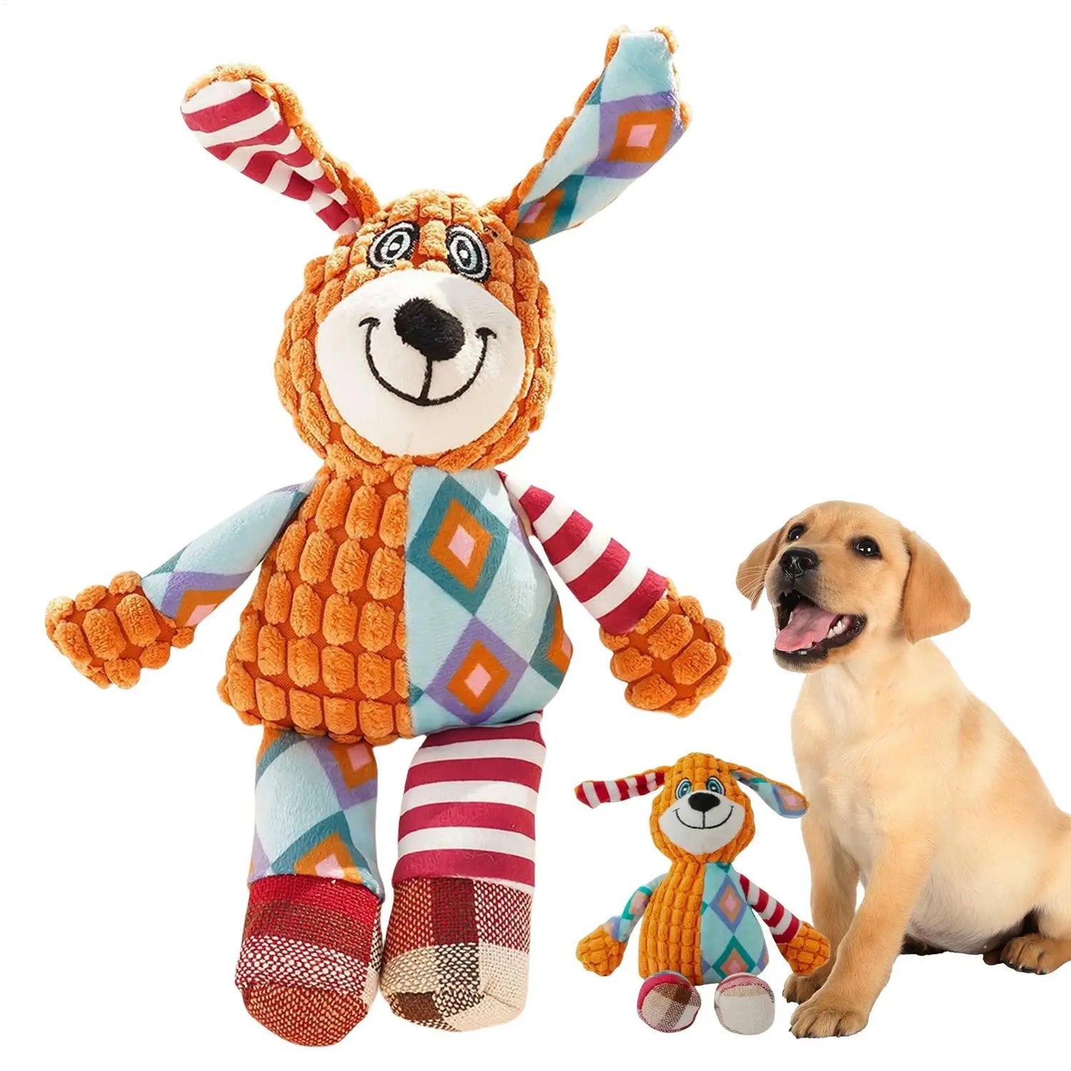 Happy puppy sitting beside colorful plush dog toy with patterned ears and limbs