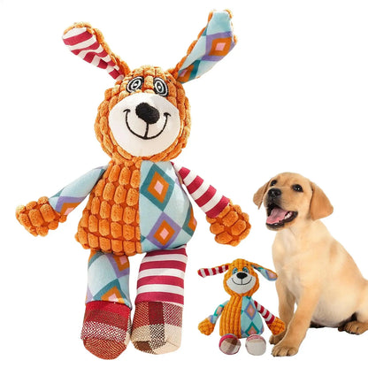 Happy puppy sitting beside colorful plush dog toy with patterned ears and limbs