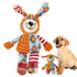 Happy puppy sitting beside colorful plush dog toy with patterned ears and limbs