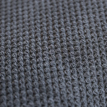 Close-up view of textured dark gray fabric pattern suitable for upholstery or bedding.