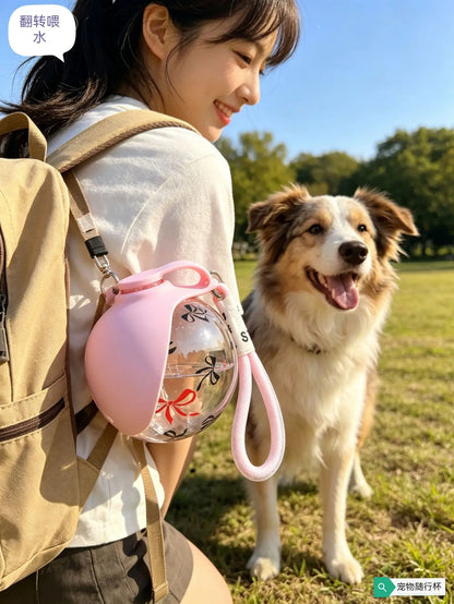 Portable dog water bottle for outdoor walks, pink leak-proof pet dispenser with handle, used beside a dog in the park