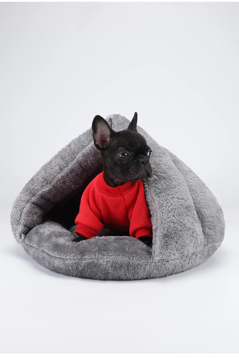 Black puppy in red sweater resting in a gray washable plush dog bed for small dogs