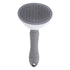 Gray dog grooming brush with ergonomic handle and fine bristles on white background
