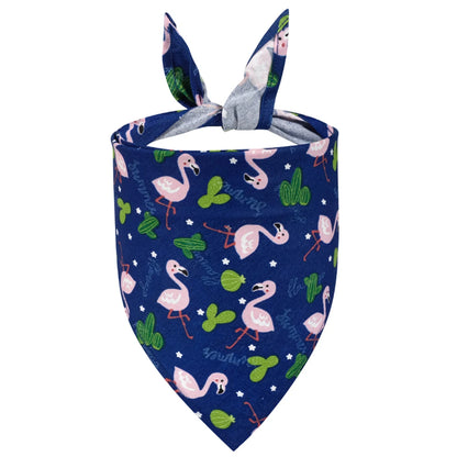 Navy blue dog bandana with pink flamingo and green cactus print, folded and tied.