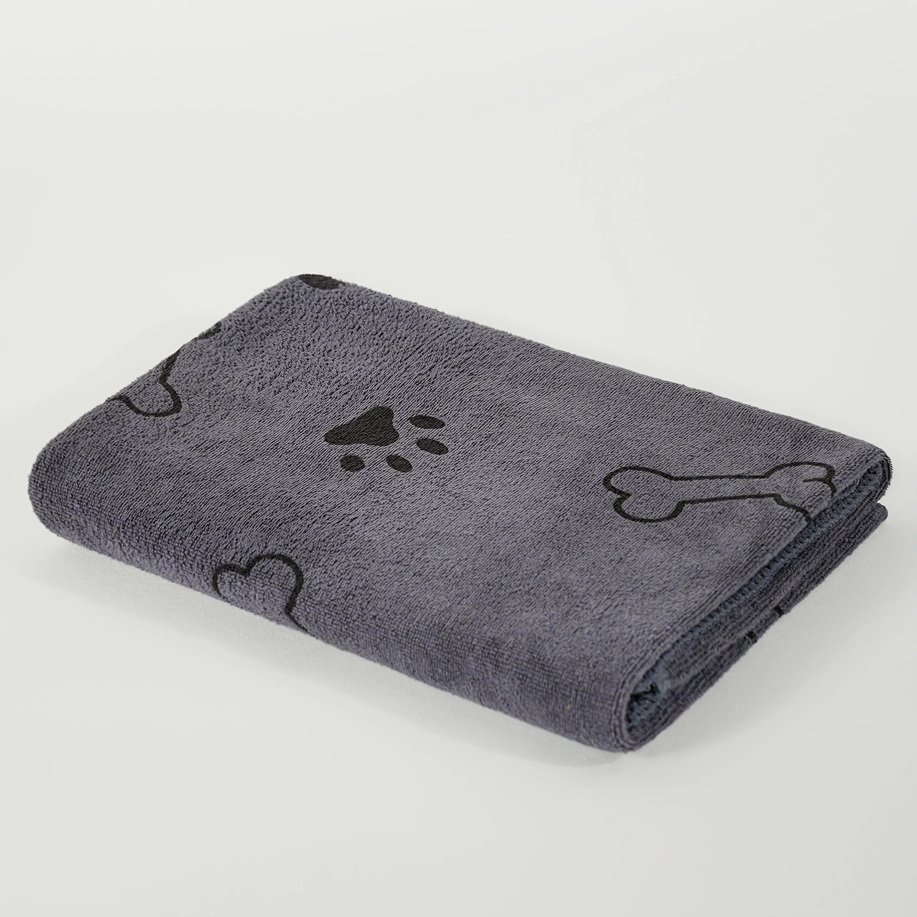 Gray dog towel with black paw print, bone, and heart patterns, folded on white background