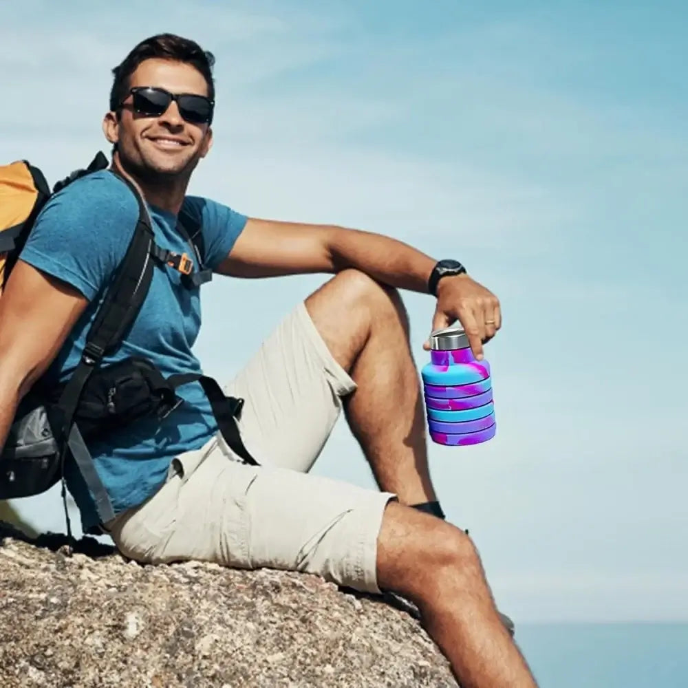 Hiker holding collapsible water bottle with carabiner, portable leak-proof travel water bottle for camping and hiking