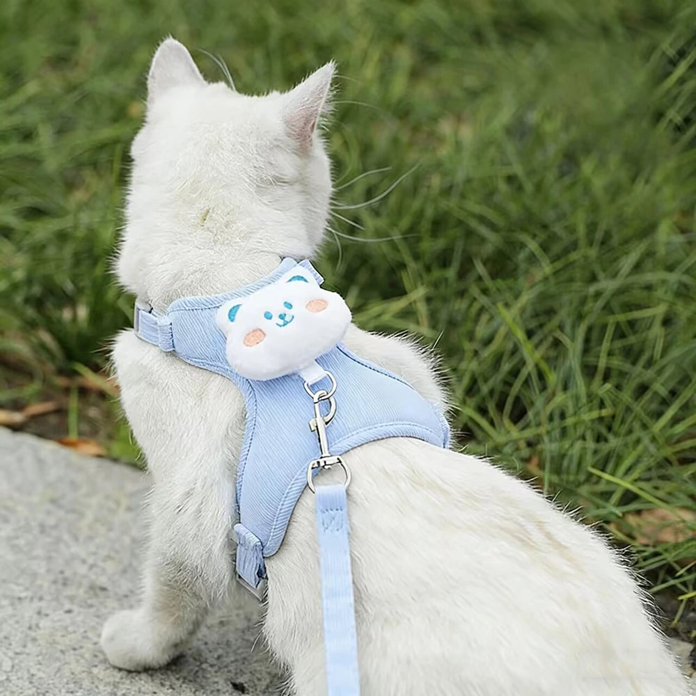 White cat wearing an adjustable cat harness leash set with cute cartoon design, ideal for safe outdoor walking