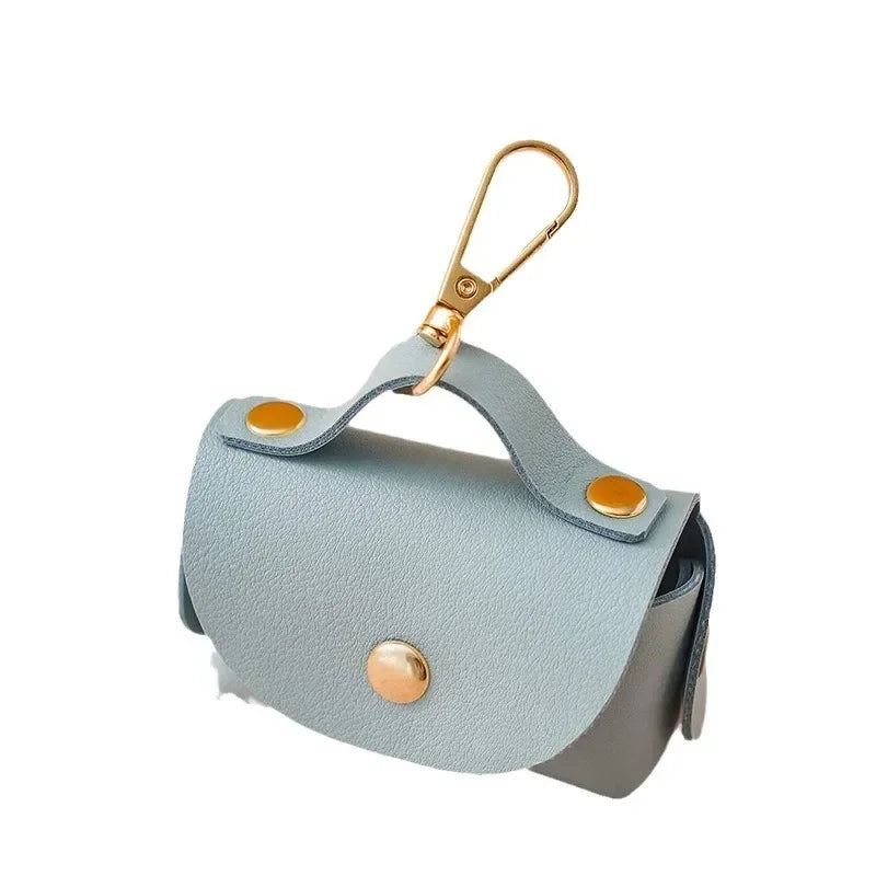 Light blue dog waste bag holder with gold snap buttons and clip, pet accessory.
