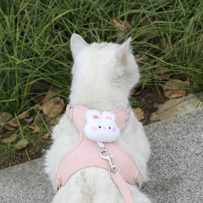 White cat wearing an adjustable cat harness leash set with pink breathable cartoon design for safe outdoor walking
