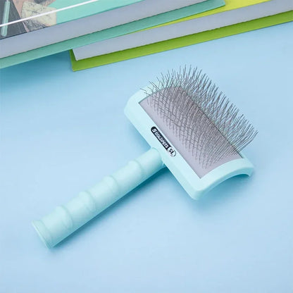 Light blue dog grooming brush with metal bristles on blue background