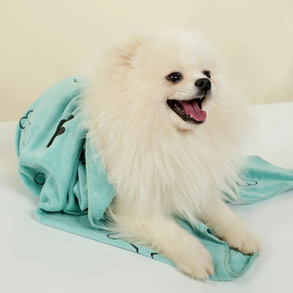 Fluffy white dog wrapped in a light blue dog towel on white background