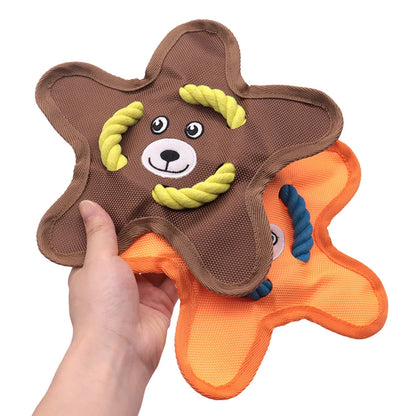 Hand holding two star-shaped dog chew toys with rope accents, brown and orange colors