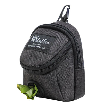 Black dog waste bag dispenser pouch with zipper, clip, and green bag protruding