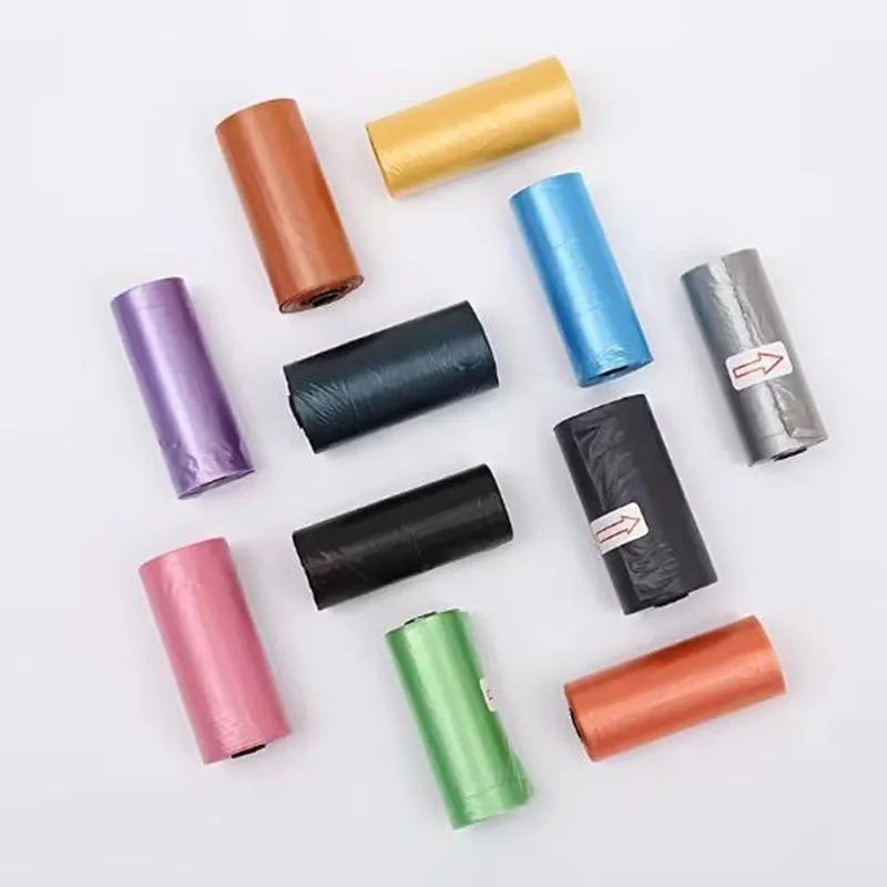 Assorted colorful dog waste bag rolls arranged on a white background.