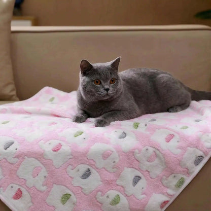 Gray cat resting on a pink soft dog blanket with elephant pattern, cozy pet bed mat for cats and dogs