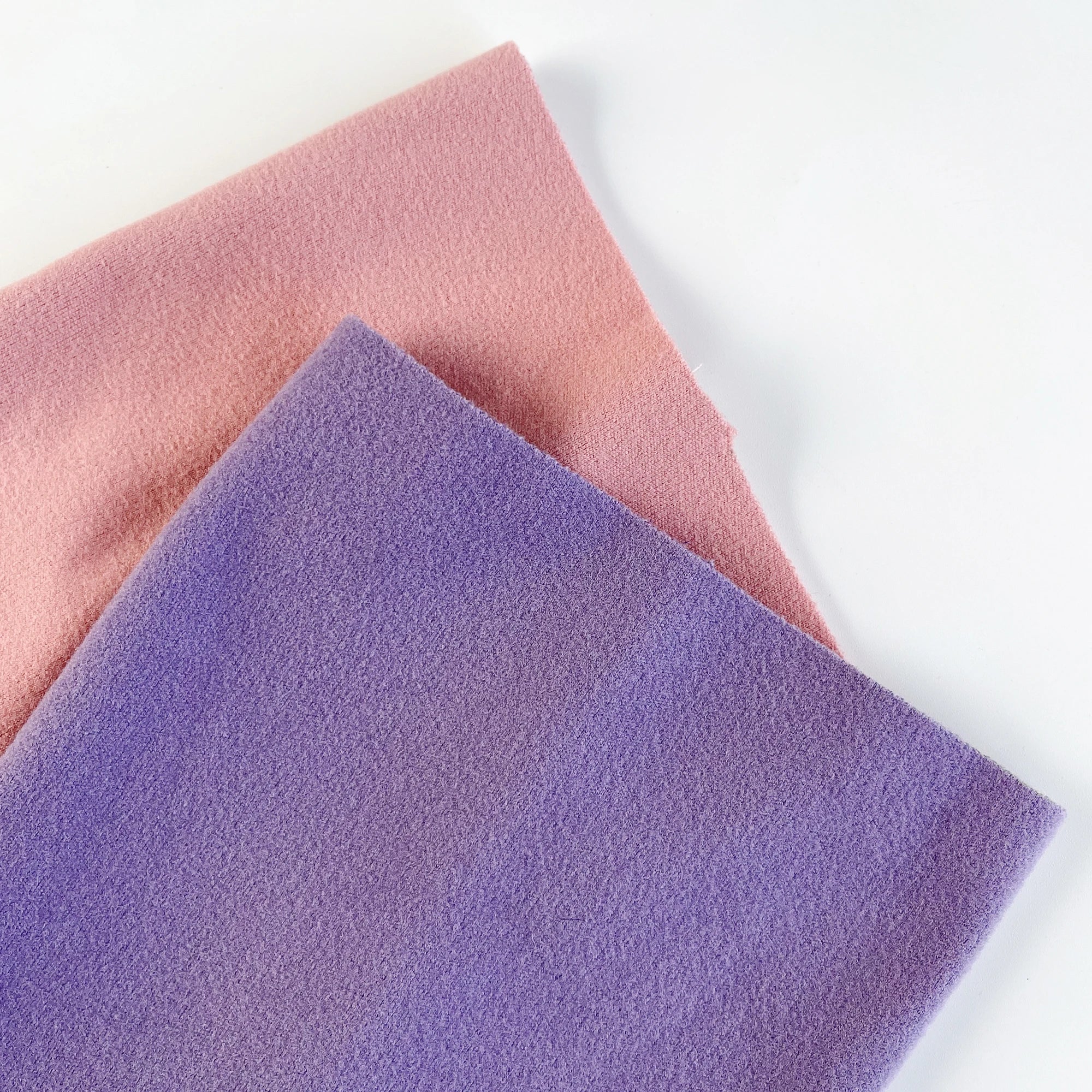 Pink and purple soft fleece fabric sheets for pet bedding or dog accessories on white background