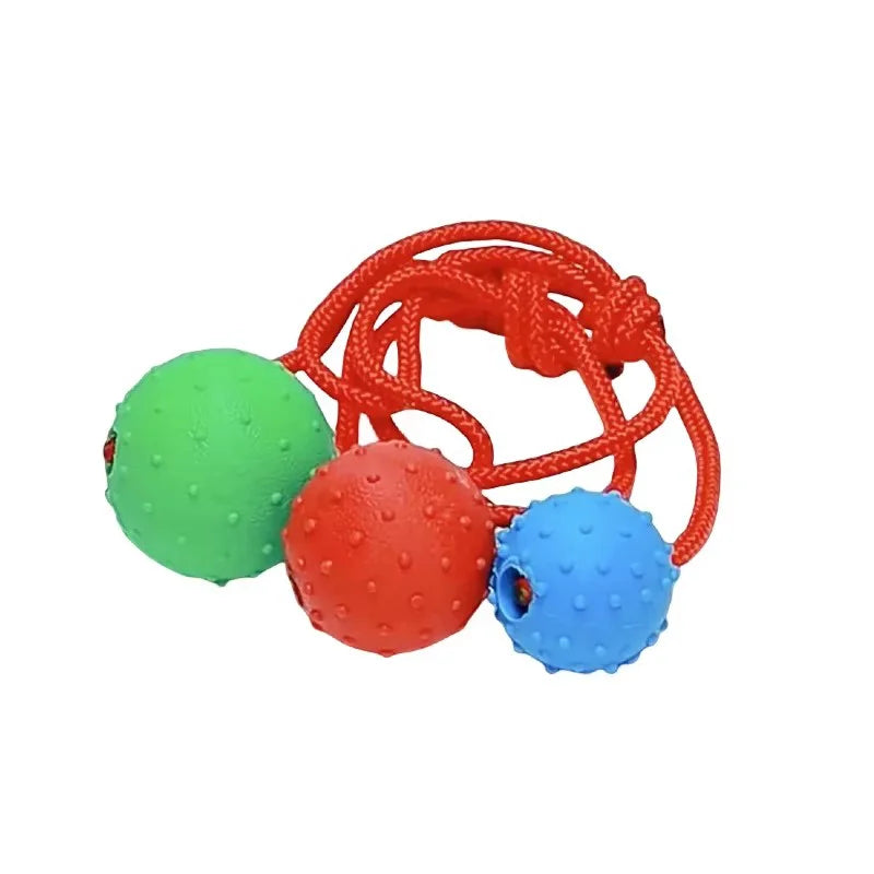 Colorful three-ball dog toy with red rope, textured green, red, and blue balls