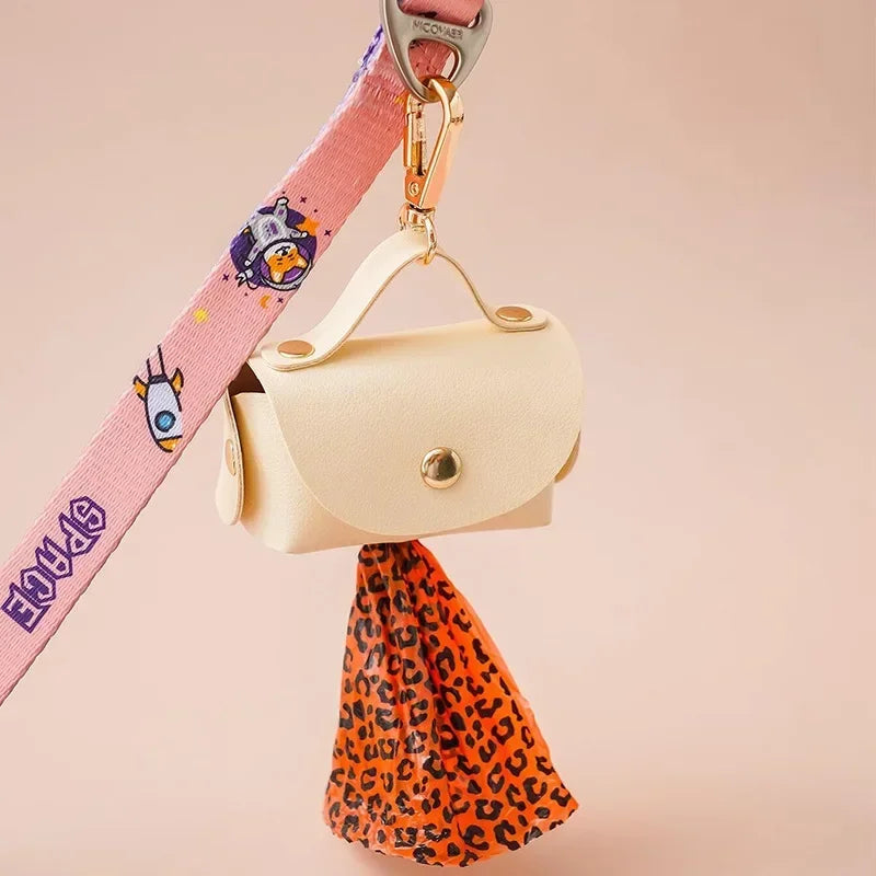 Dog waste bag holder with orange leopard print poop bag, attached to pink dog leash