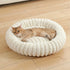 Beige plush donut cat bed with ultra soft round bolster, cozy warm nest for small medium cats and dogs on wooden floor