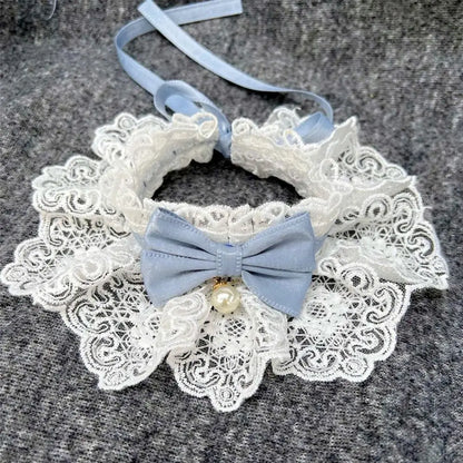 Elegant lace dog collar with blue bow and pearl charm on gray fabric background