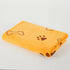 Folded yellow dog towel with brown paw prints and bone patterns on white background