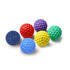 Colorful textured dog toy balls in blue, red, yellow, green, and purple on white background