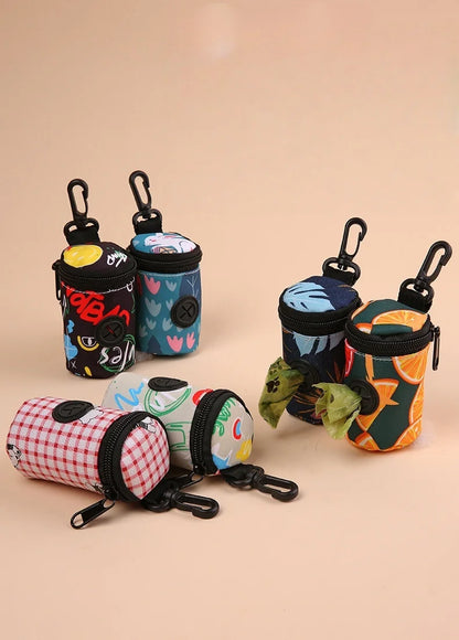 Assorted colorful dog waste bag holders with clips and patterned designs on a beige background.