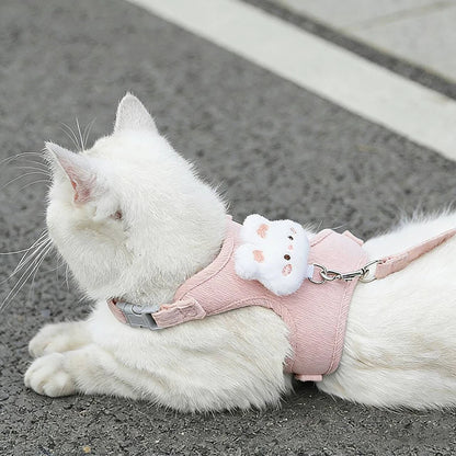 White cat wearing a pink adjustable cat harness and leash set with cute plush decoration, safe breakaway walking accessory