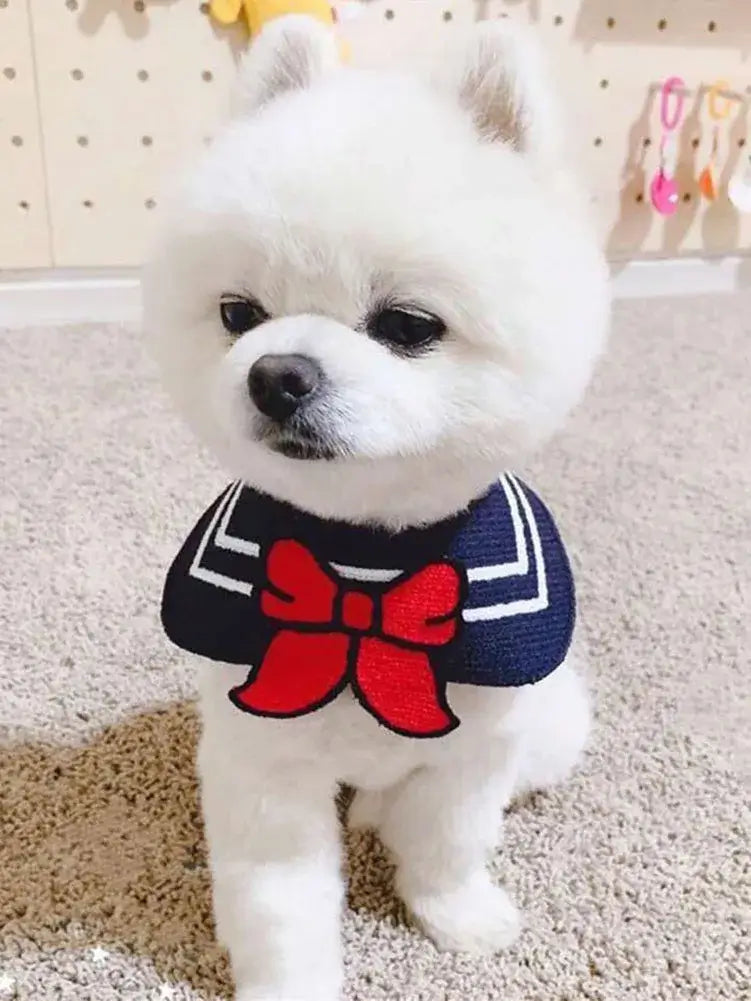 White puppy wearing a navy pet bandana with red bow, cute pet neckerchief costume accessory for dogs and cats
