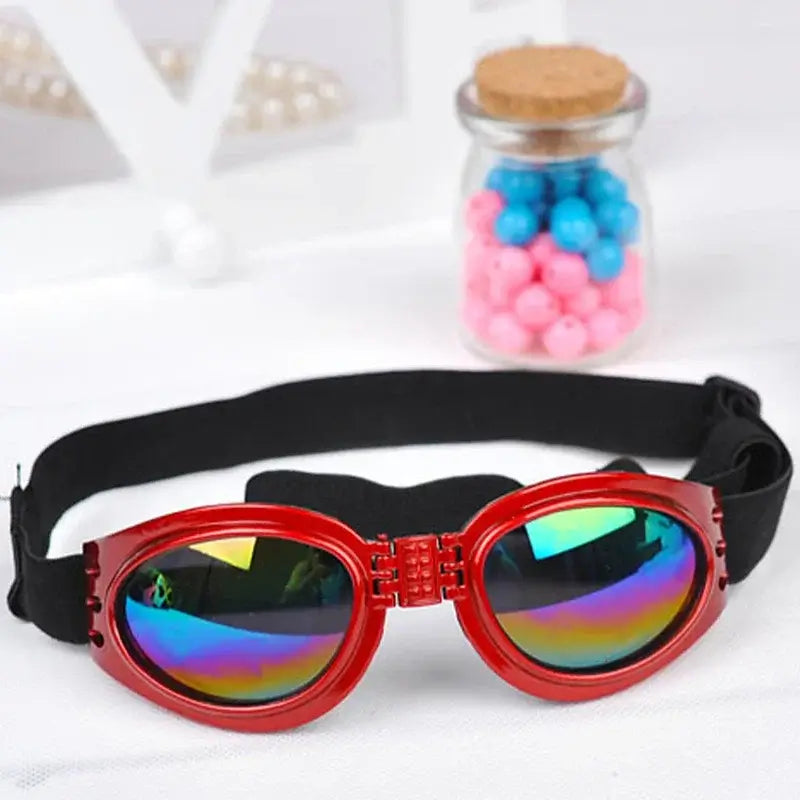 Red dog sunglasses with foldable round lenses, black chin strap, and windproof sunscreen design for summer pet use