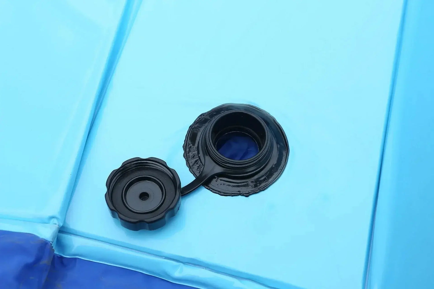 Close-up of the drain valve on a portable dog bathing tub for easy water release.