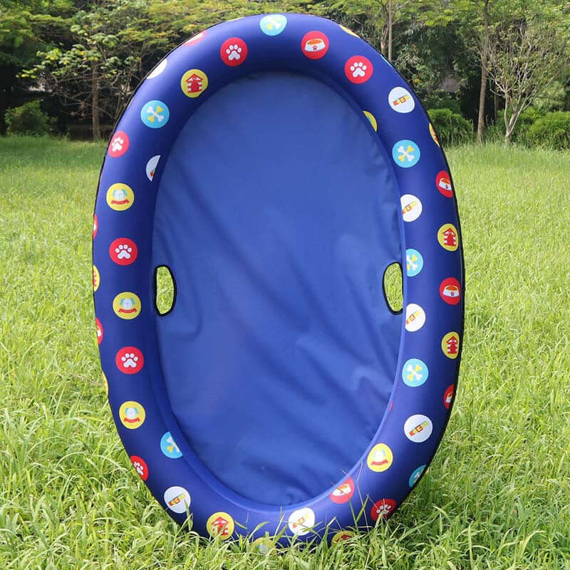 inflatable dog swimming pool float in dark blue with colorful designs on the edges, set on grassy background.