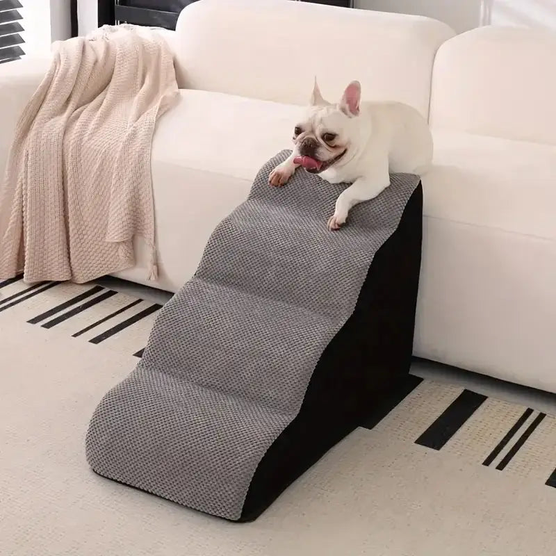 Memory foam dog stairs for small pets resting against a couch with a French Bulldog on top.