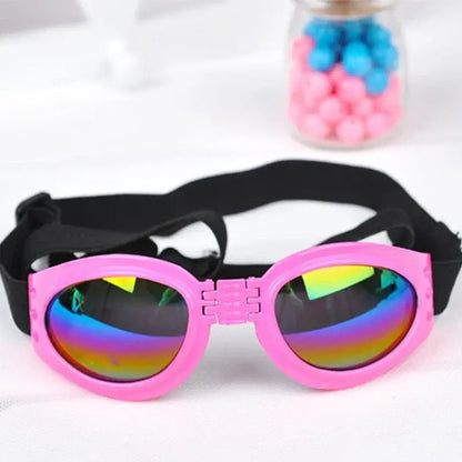 Pink dog sunglasses with rainbow lenses and adjustable strap, foldable pet goggles for summer sun and wind protection