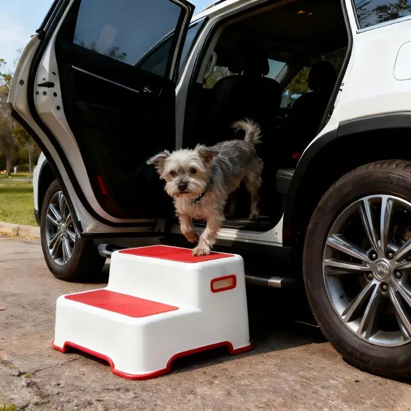 Portable dog stairs for small breeds next to a car, helping a small dog get in easily.