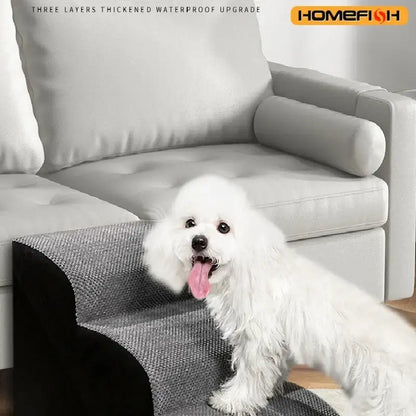 Washable memory foam dog stairs with a fluffy white dog using the ramp next to a gray couch.